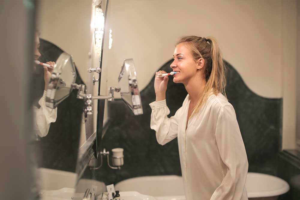 a young is brushing her teeth
